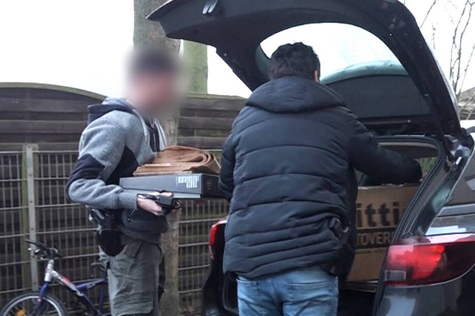 Castrop-Rauxel: Bei einer Razzia laden Zivilermittler der Polizei vor einem Haus Kartons in ein Auto.
