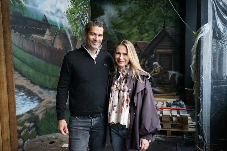 Die "Storygolf"-Gründer Iryna und Martin Thater auf der Baustelle in der HafenCity. Im Hintergrund sind die handgemalten Bilder der Hammaburg zu sehen.