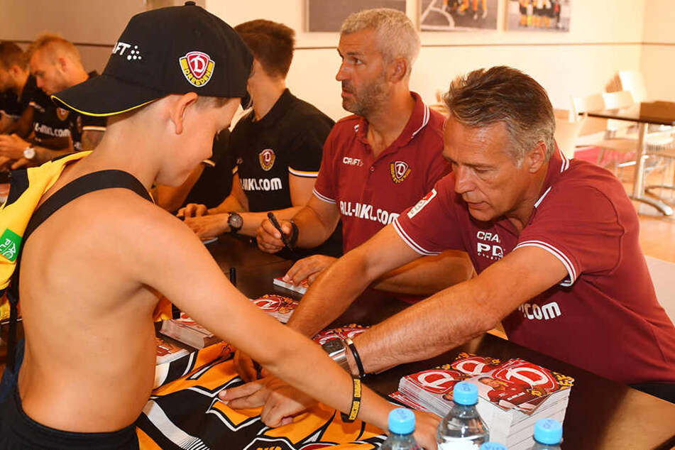 Immer für die Fans da: Uwe Neuhaus (r.) schreibt fleißig Autogramme.