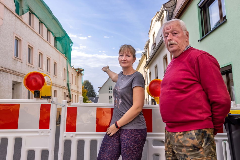Die Anwohner Christin Walther (37) und Hubert Hartinger (70) blicken mit Sorge auf das stark reparaturbedürftige Haus.
