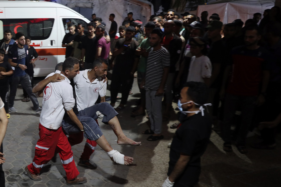 Ein verletzter Palästinenser wird in Deir al-Balah von Sanitätern getragen.