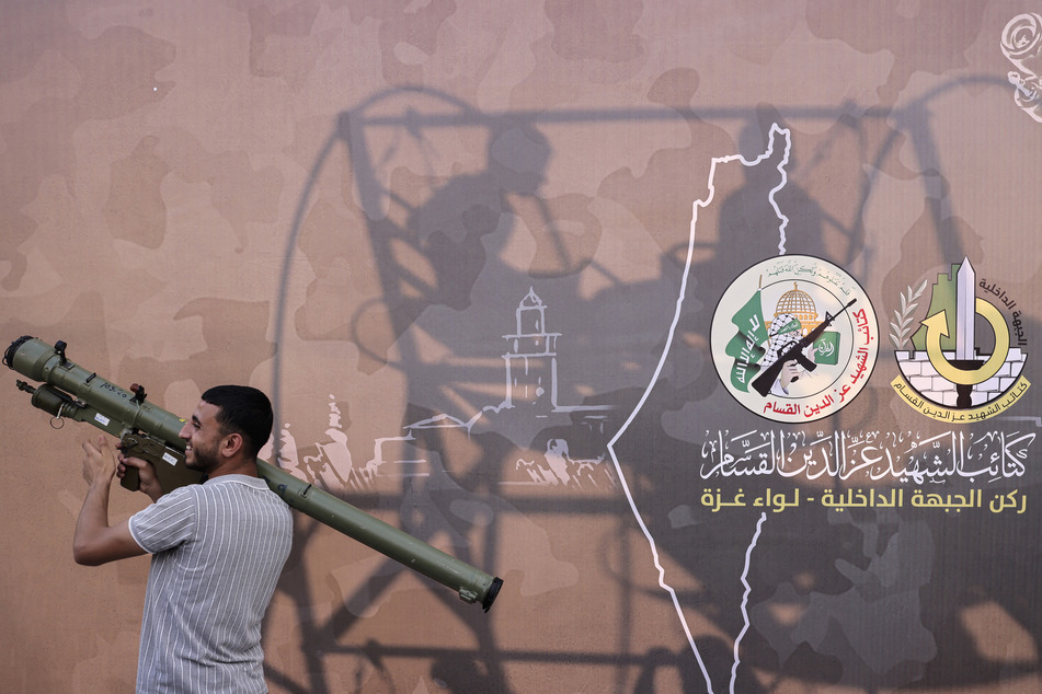 A Palestinian poses for a souvenir picture with an RPG launcher during an exhibition by the Ezzedine al-Qassam Brigades, the military wing of the Palestinian Hamas movement, in Gaza City on June 30, 2023.