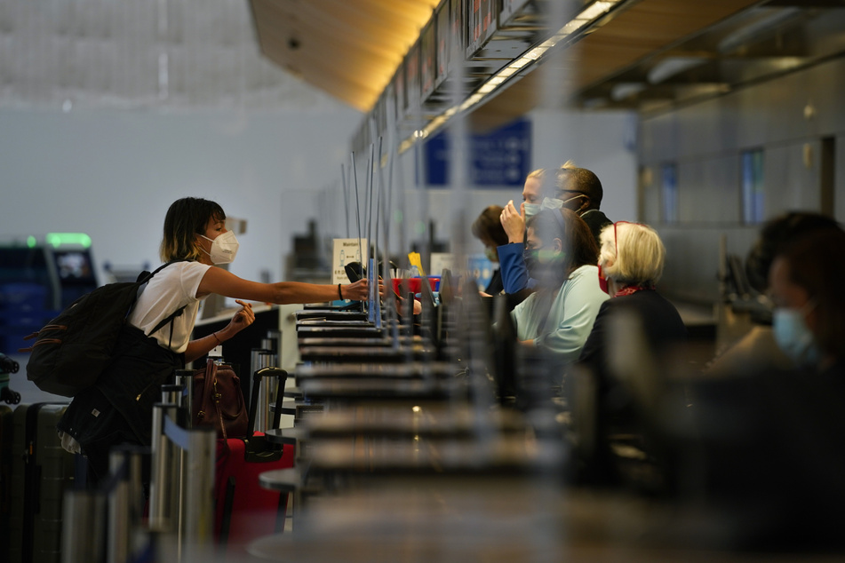 Eine Frau mit Mund-Nasen-Schutz checkt auf dem internationalen Flughafen von Los Angeles für ihren Flug ein.