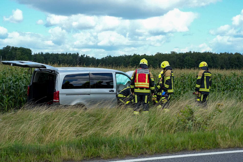 Mehrere Feuerwehrleute begutachten vor Ort das Unfallfahrzeug.