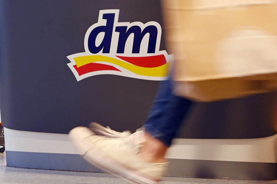 Eine Person geht in einer Filiale der Drogeriemarktkette dm vorbei.