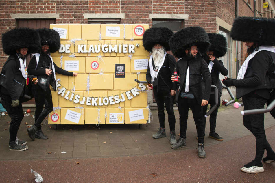 Mitglieder der Gruppe "De Kalisjekloesjers" stehen bei einem Karnevalsumzug neben einer Attrappe der Klagemauer und haben sich als orthodoxe Juden verkleidet.