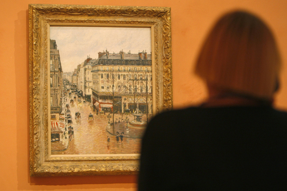 A visitor views "Rue Saint-Honoré in the Afternoon. Effect of Rain" at the Thyssen-Bornemisza Museum in Madrid, Spain.