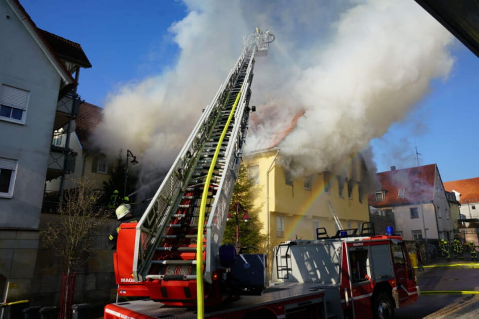 Die Feuerwehr kämpft mit einer Drehleiter gegen die Flammen.