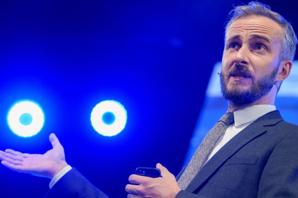 TV-Moderator und Musiker Jan Böhmermann steht auf einer Bühne im Rampenlicht.