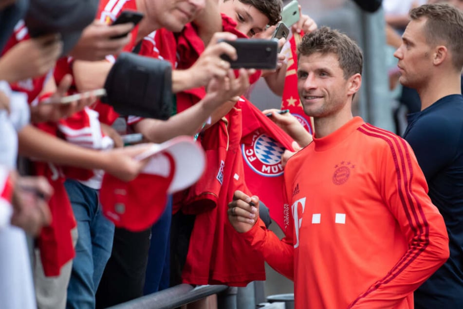 Thomas Müller (l) und Torwart Manuel Neuer schreiben nach dem Training Autogramme.