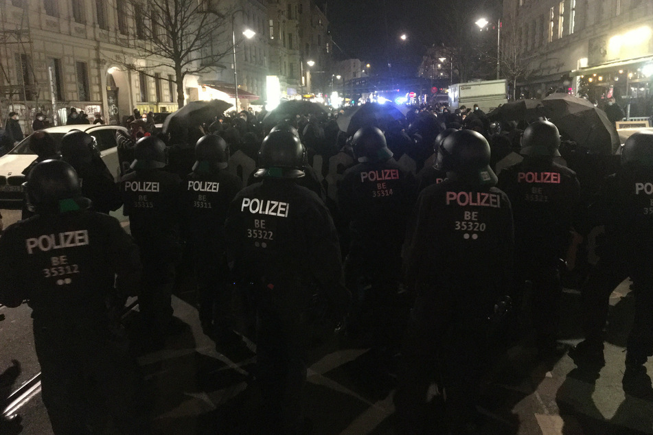 Polizisten und Demonstranten stehen am Donnerstagabend auf der Kastanienallee in Berlin-Prenzlauer Berg.