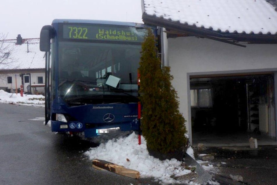 Der Linienbus ist über eine glatte Straße geschlittert und gegen eine Hauswand gekracht.