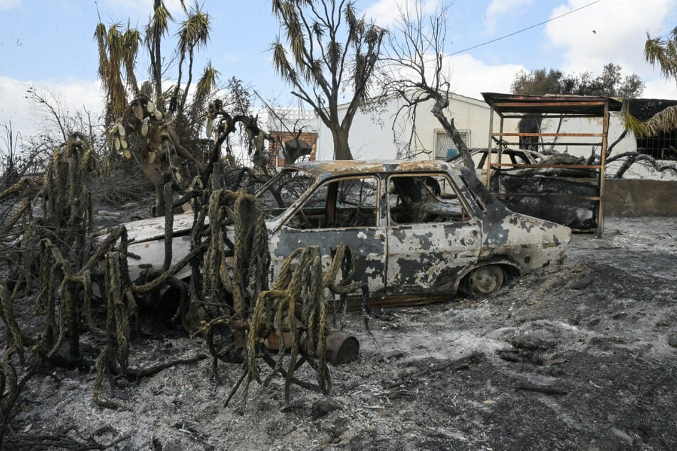 Ein ausgebranntes Auto, das bei dem schweren Waldbrand beschädigt wurde.