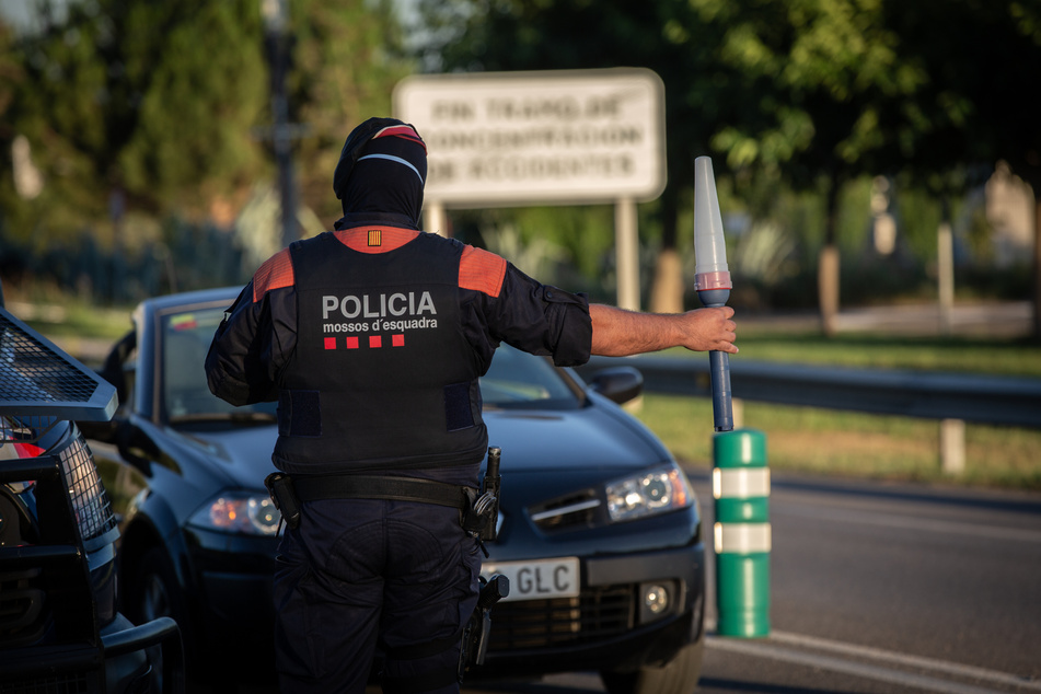 Ein Polizist kontrolliert der spanischen Stadt Lleida den Zugang zur Autobahn Richtung Barcelona. Politik und Justiz streiten in Spanien aktuell über die Auslegung der Corona-Maßnahmen.