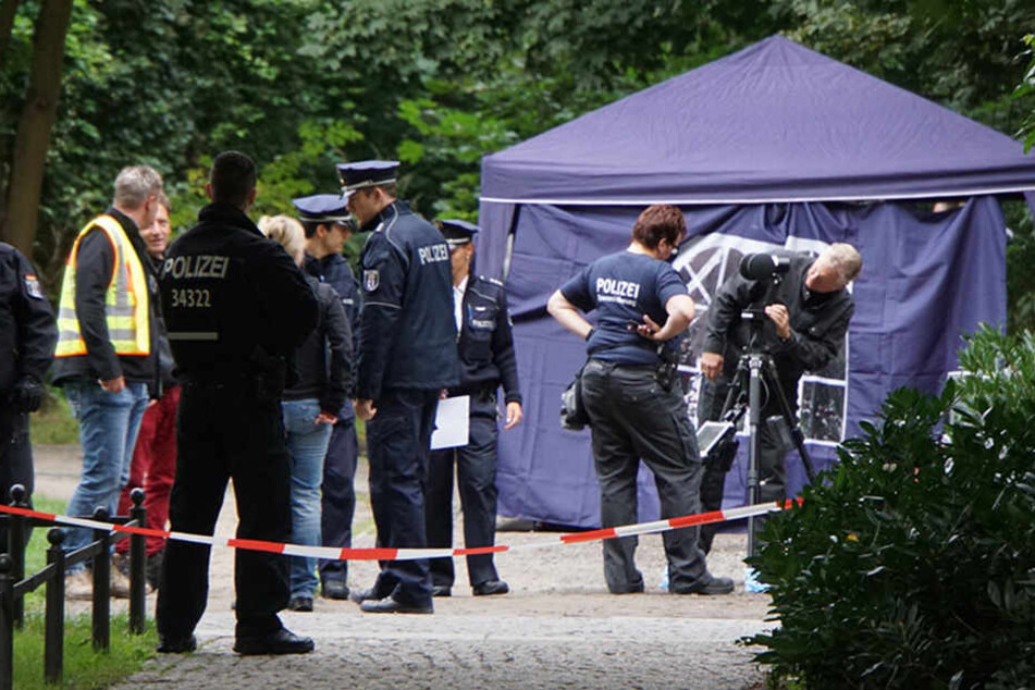 Mehrere Beamte haben den Park, in dem die Leiche des Obdachlosen gefunden wurde, nach Indizien untersucht.