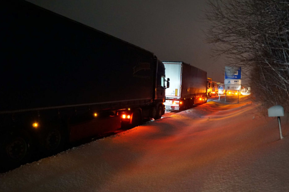 Mehrere Lkw fuhren sich auf der glatten und verschneiten Autobahn fest.