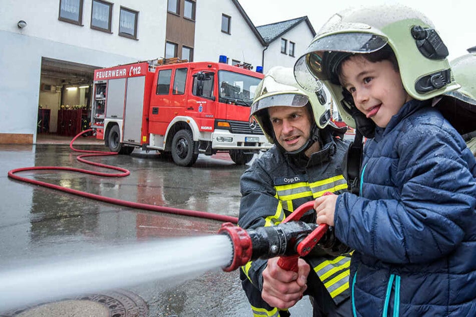 Das macht Spaß! Bilal (5) probierte mit Feuerwehrmann Daniel Opp (38) den Wasserschlauch aus.
