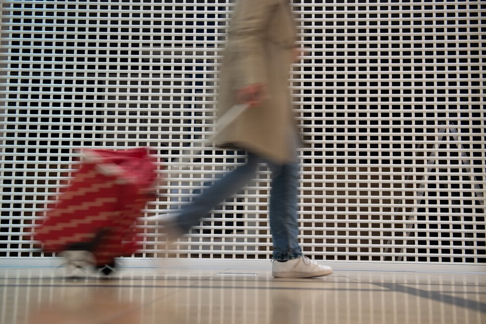 Eine Frau geht mit einem Trolley bei geschlossenen Geschäften entlang. Zwar können Händler in Sachsen nun "Click & Collect" anbieten. Doch eine richtige Öffnung ersetzt das nicht.