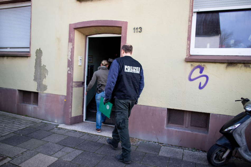 Beamte der Spurensicherung gehen in ein Mehrfamilienhaus.