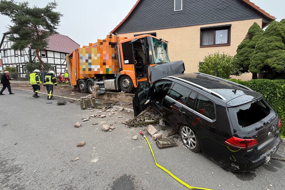 Das Fahrzeug der Müllabfuhr und ein Volkswagen blieben vor einem Haus stehen.