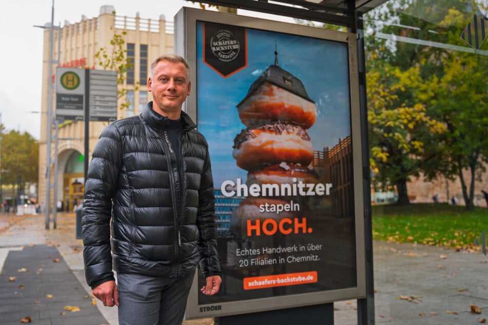 Dirk Schäfer vor einem Werbeplakat in der Chemnitzer Innenstadt.