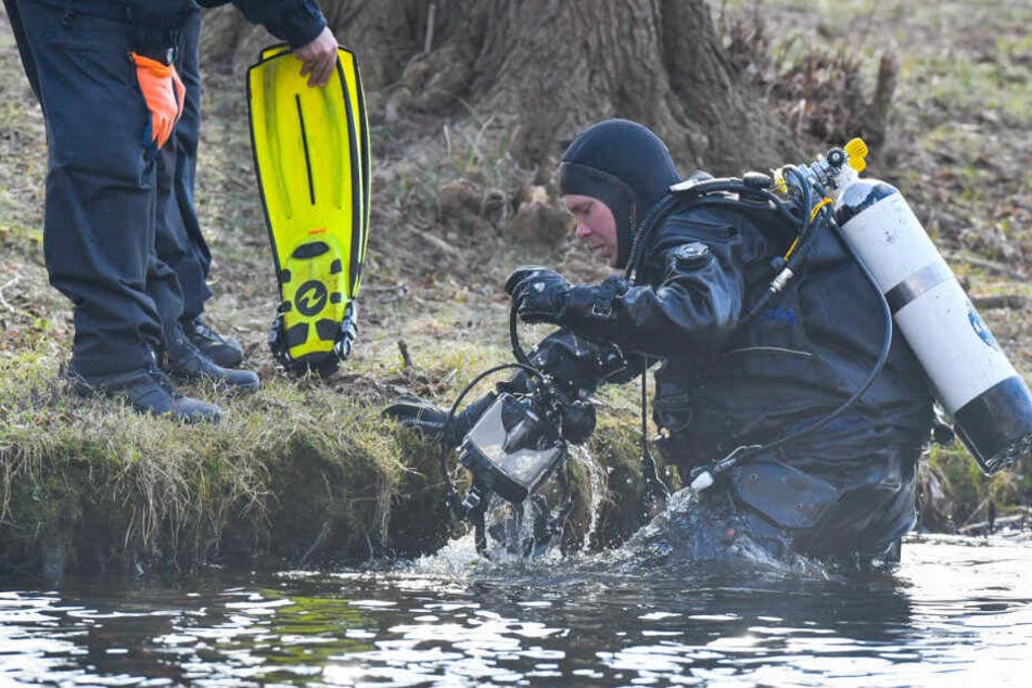Ein Polizeitaucher kommt aus dem Wasser des Storkower Sees.