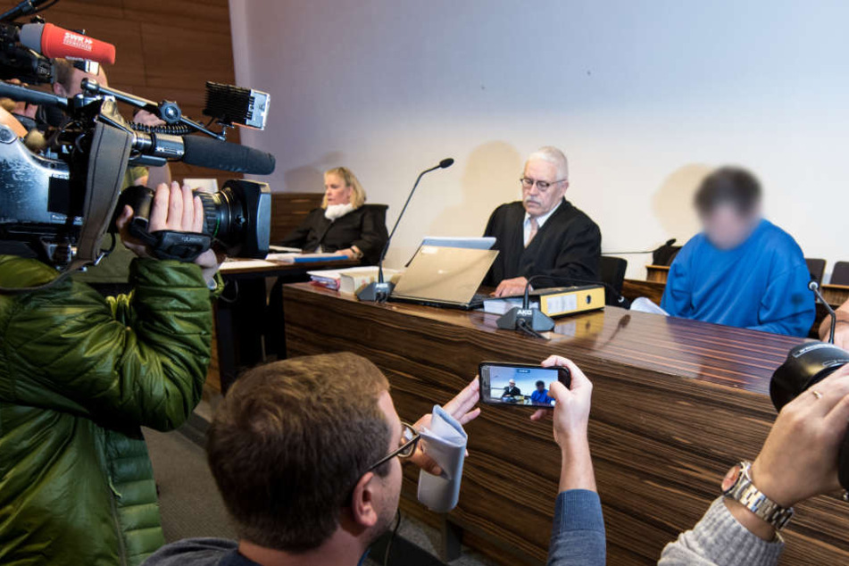 Der angeklagte 40-Jährige Lastwagenfahrer (2.v.r.) sittzt im Sitzungssaal des Landesgerichts Freiburg neben seinem Verteidiger.