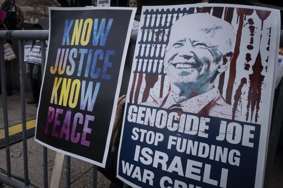Signs reading "Know Justice Know Peace" and "Genocide Joe, Stop Funding Israeli War Crimes" are on display during a protest in Washington DC.