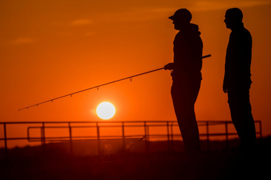 Zwei Angler bei Sonnenuntergang. (Symbolbild)