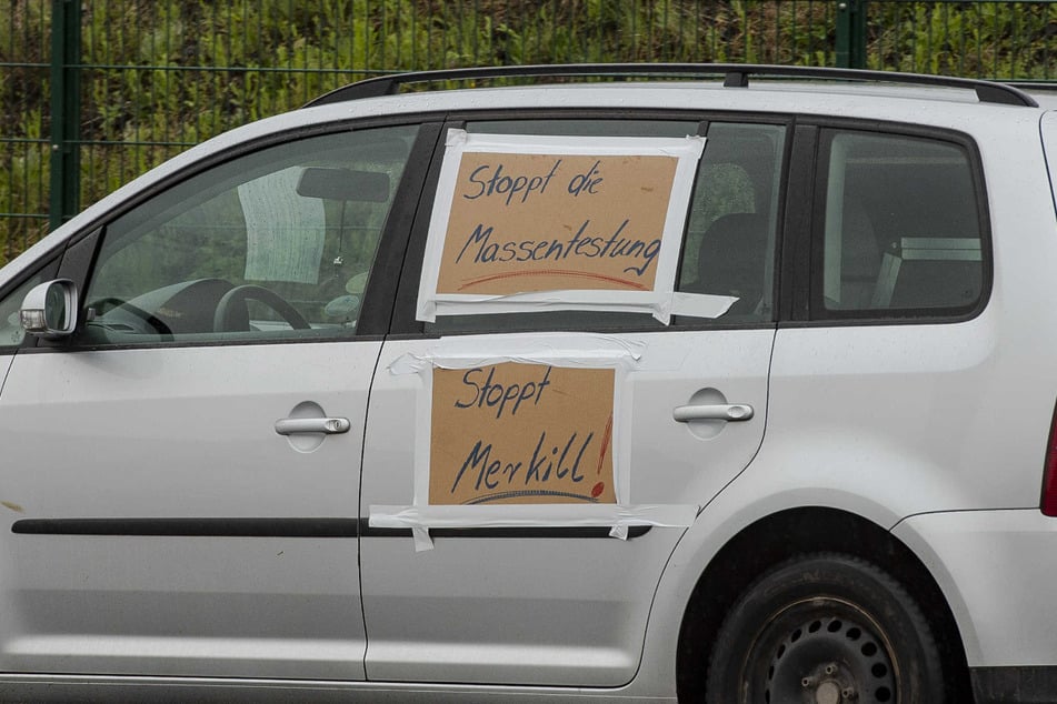 "Stoppt die Massentestung" und "Stoppt Merkill!" steht auf einem Auto, welches an der Demo teilnahm.