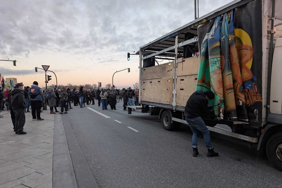 Der Aufbau ist gestartet. Etliche Menschen warten mit Musik auf den Beginn der Demonstration.