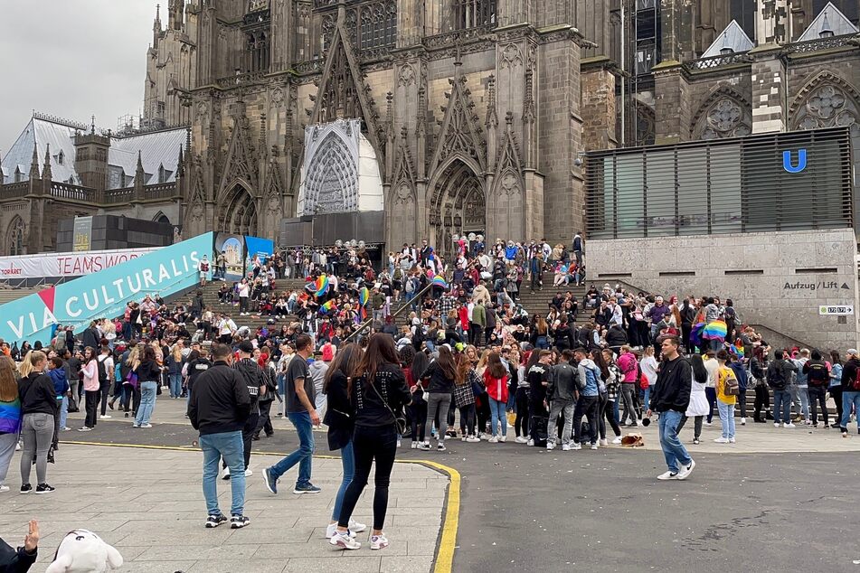 Menschen versammeln sich am Kölner Dom für die CSD-Parade.
