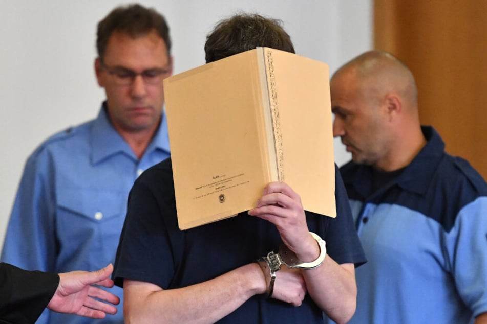 Mit einem Aktenordner vor dem Gesicht, betritt der mutmaßliche Mörder Silvio S. am 26.07.2016 für die Verkündung des Urteiles in Potsdam (Brandenburg) einen Saal des Landgerichtes. (Archivbild)