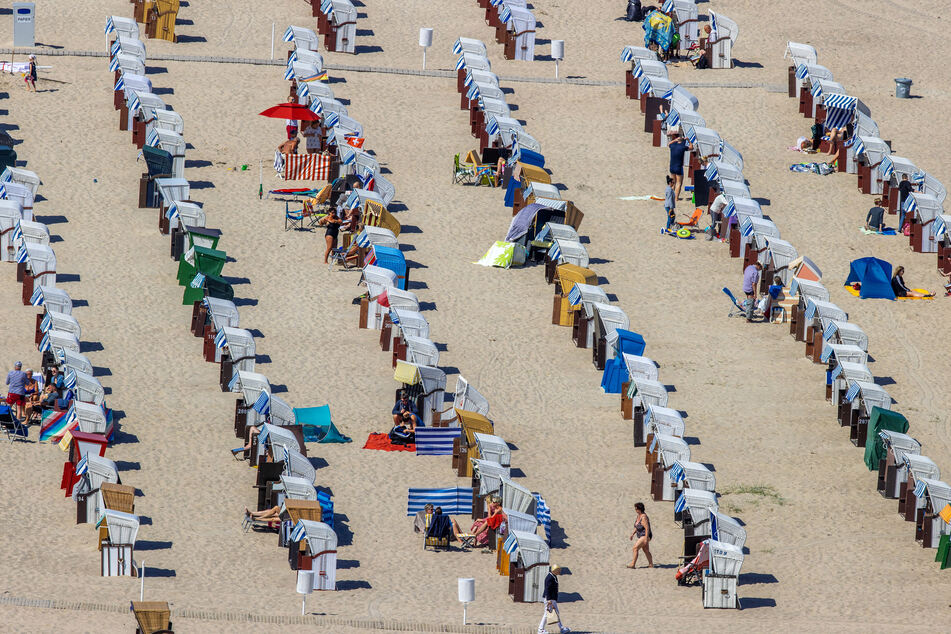 Urlauber genießen das Sonnenwetter am Ostseestrand in Warnemünde.