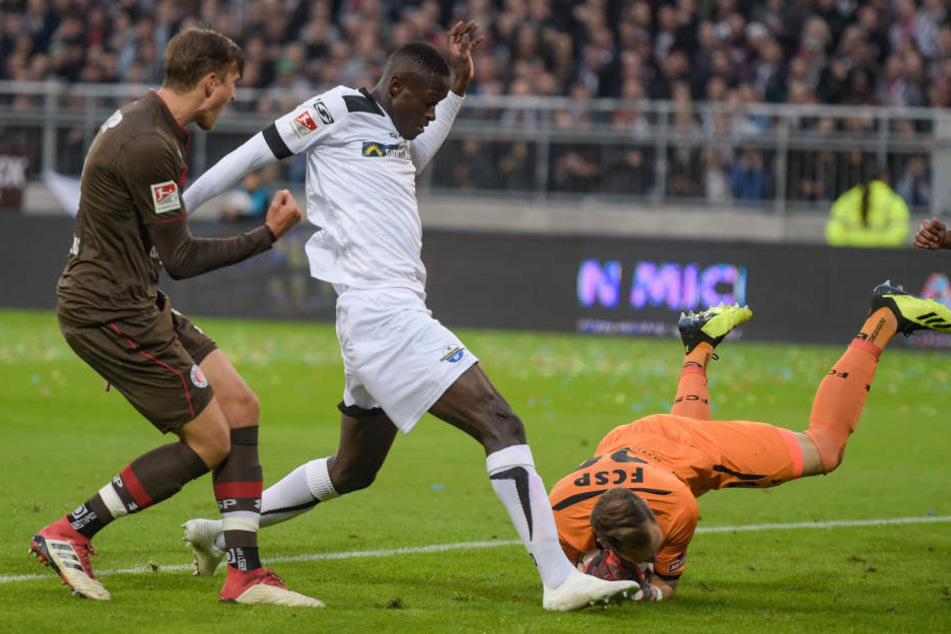 Pauli-Keeper Robin Himmelmann rettet vor Paderborns Babacar Guèye.