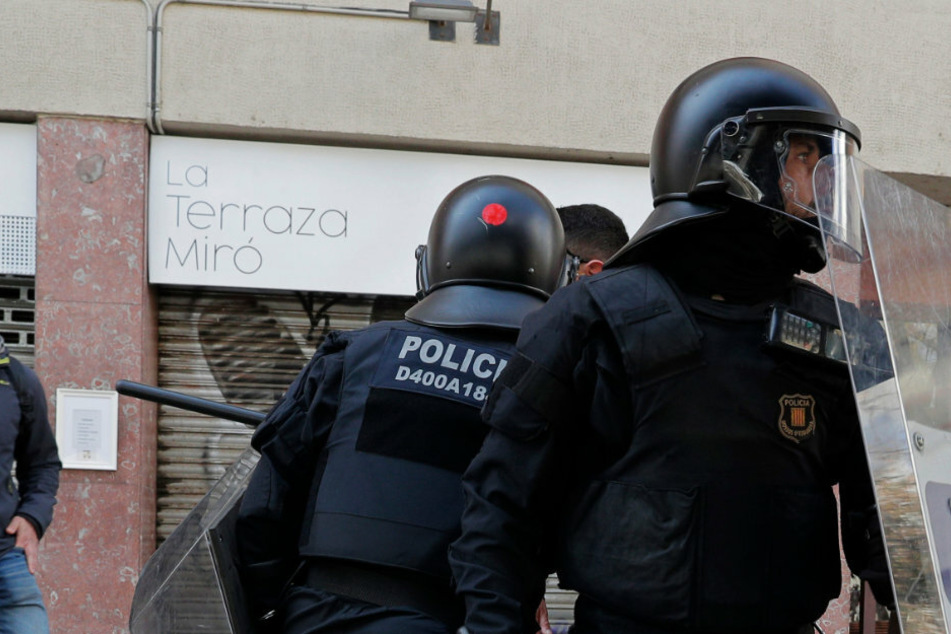 Spanische Polizeibeamte stehen in Barcelona auf der Straße (Symbolbild).