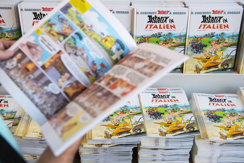 Ein Kunde einer Buchhandlung liest im Asterix-Band "Asterix in Italien".