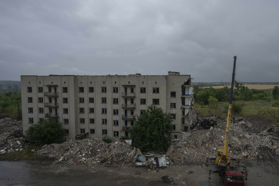 Ukrainische Rettungskräfte versuchen nach einem russischen Raketenangriff auf ein Wohnhaus in Tschassiw Jar Menschen aus den Trümmern zu befreien.