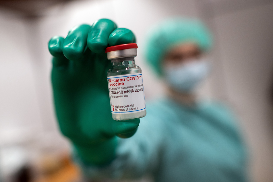 Eine Mitarbeiterin des Universitätsklinikums hält ein Gläschen mit dem Impfstoff von Moderna gegen Covid-19.