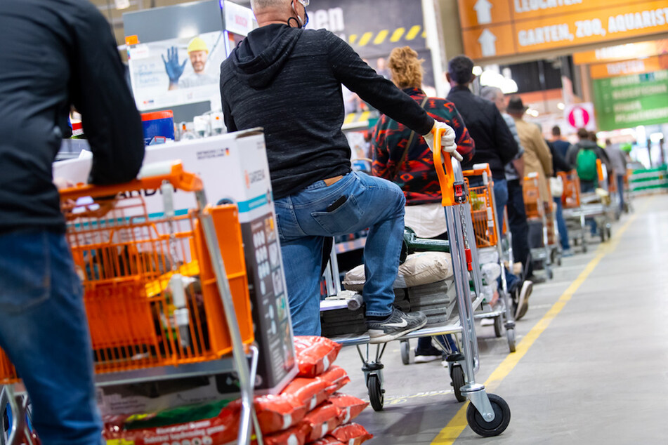Kunden stehen im Frühjahr 2020 mit Einkaufswagen in einem Hornbach-Baumarkt in einer Schlange vor den Kassen an.
