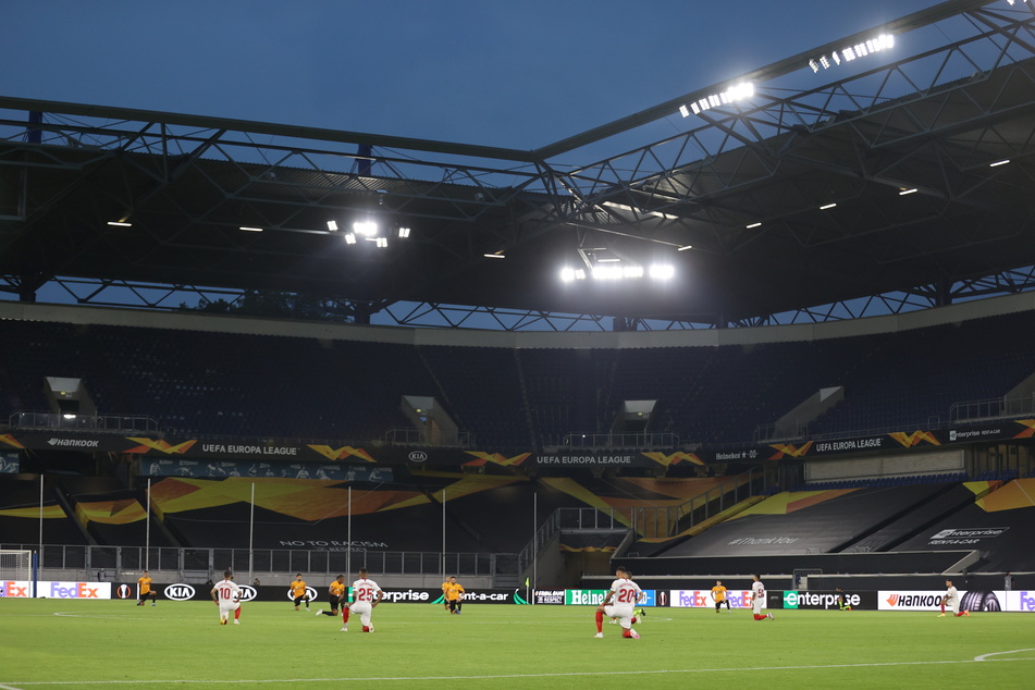 Die Spieler knien vor Spielbeginn auf dem Rasen um ein Zeichen gegen Rassismus zu setzen.