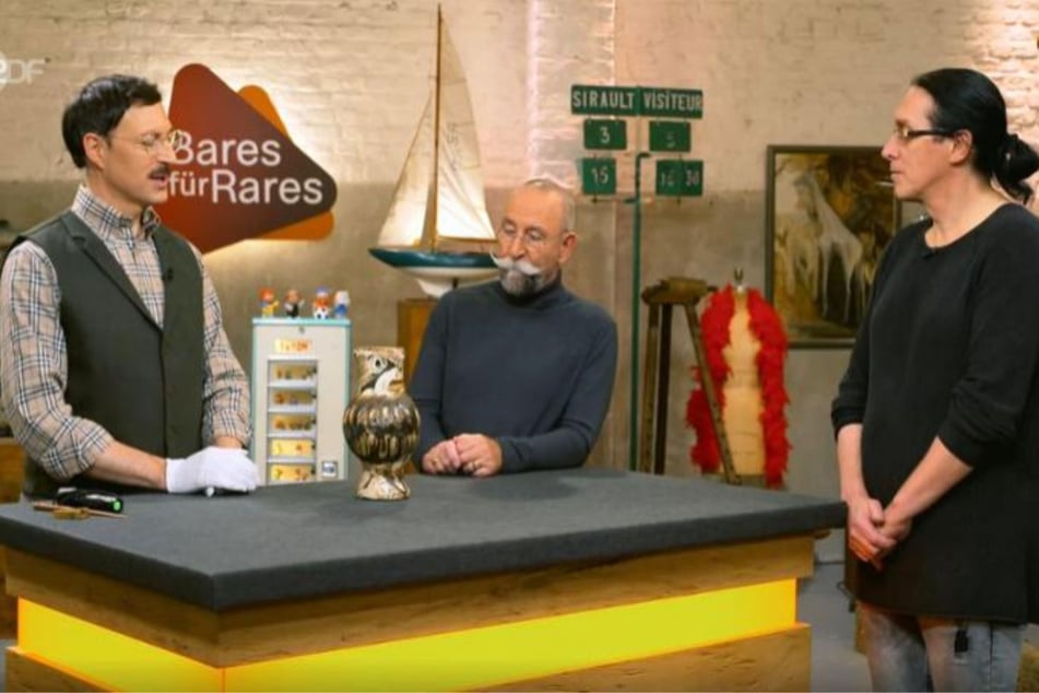 Joachim Beckers (r.) aus Chemnitz möchte bei "Bares für Rares" einen Eulen-Krug verkaufen.