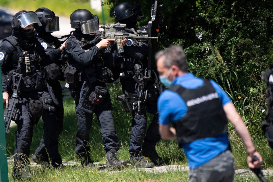 Schwerbewaffnete Polizisten verfolgen den Verdächtigen.