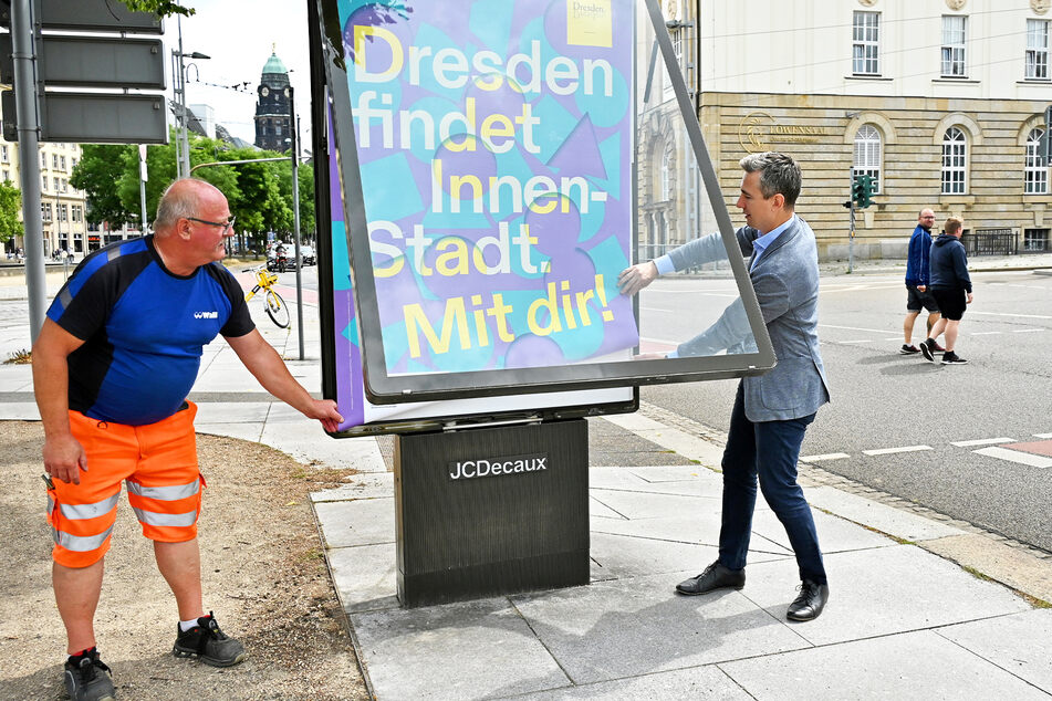 Stephan Kühn (43, Grüne, r.) hilft beim Anbringen des Plakates.