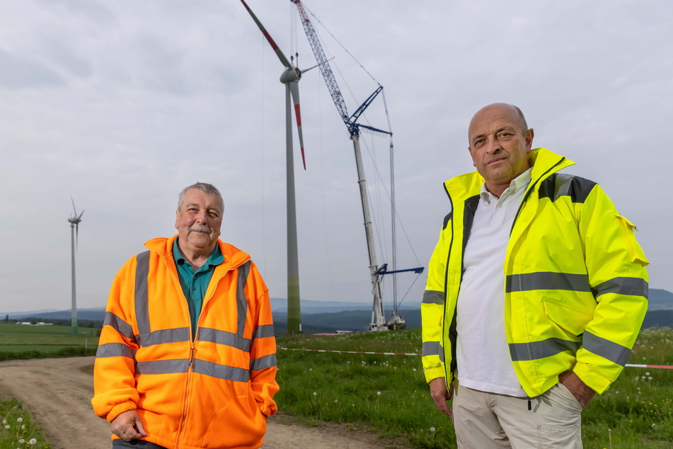 Fast geschafft: Thomas Hachman (59, r.), Geschäftsführer "Erzwind", und Bauleiter Roberto Hessler (62) vor dem neuen Windrad in Jöhstadt, während die letzten Montage-Arbeiten laufen.