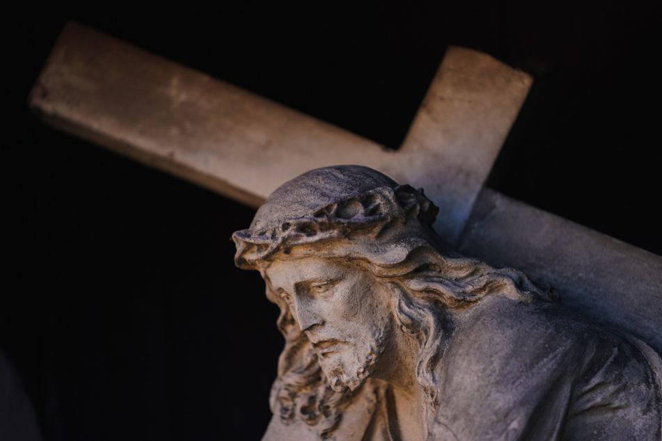Eine Figur des Jesus Christus mit dem Kreuz ist an einer Fassade in der Bamberger Altstadt zu sehen. Die Kirchen bereiten sich auf Ostern in der Corona-Pandemie vor.