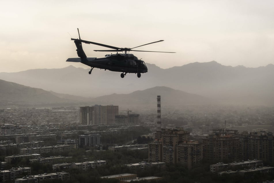 A US Army Black Hawk flies over the city of Kabul.