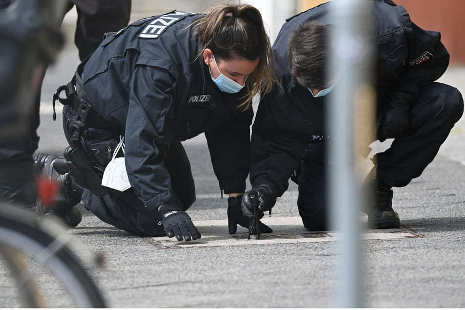 Polizisten suchen auf dem Fußweg und neben den Gebäuden des diakonischen Anbieters Oberlinhaus nach Spuren.