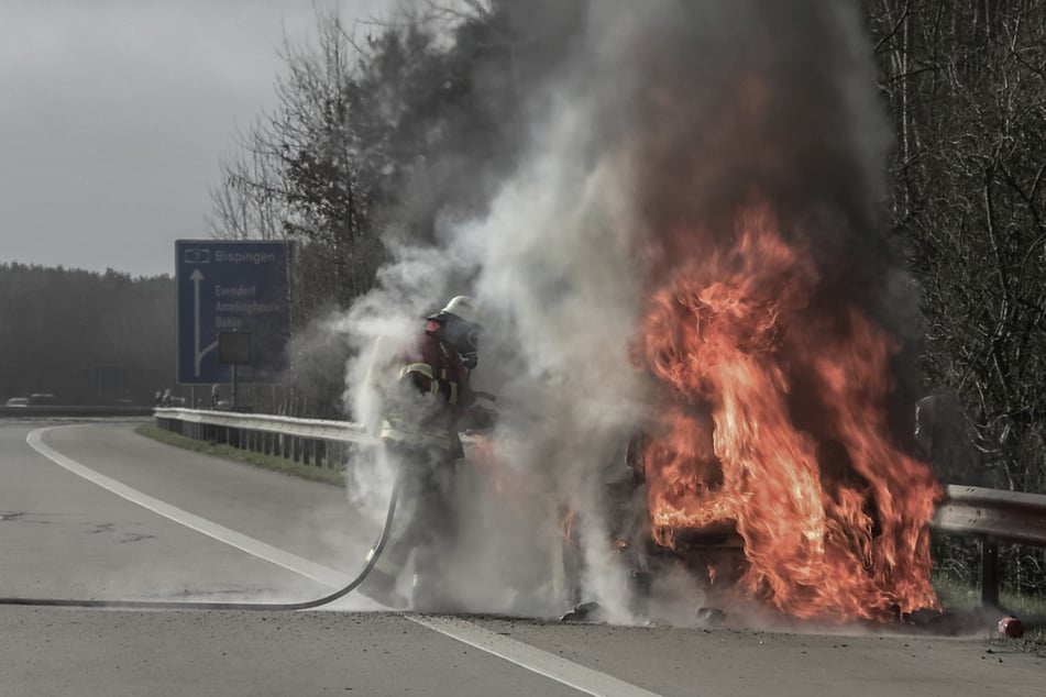 Die Feuerwehr löscht den in Flammen stehenden Audi auf der A7 bei Evendorf.