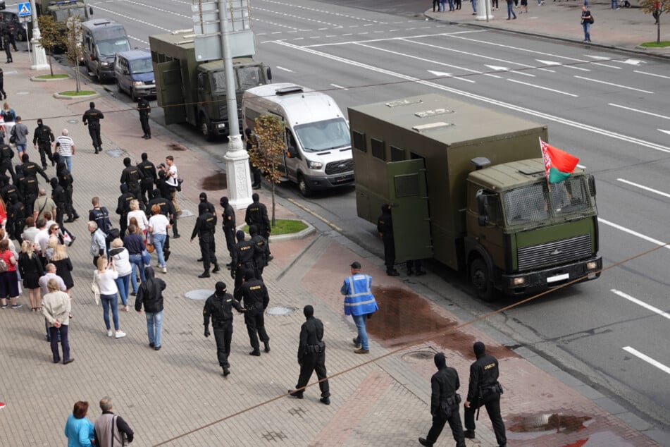 Bereitschaftspolizisten stehen vor dem Gefangenentransporter.